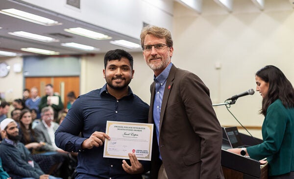 Student holding award certificate at ceremony