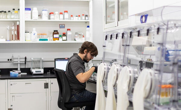 Student sitting in chair in a white lab